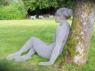 Садовая скульптура девушки у дерева из сетки-рабицы